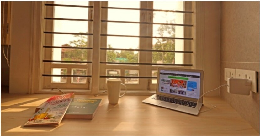 Study desk with reading lamp in a Positive Aura PG room